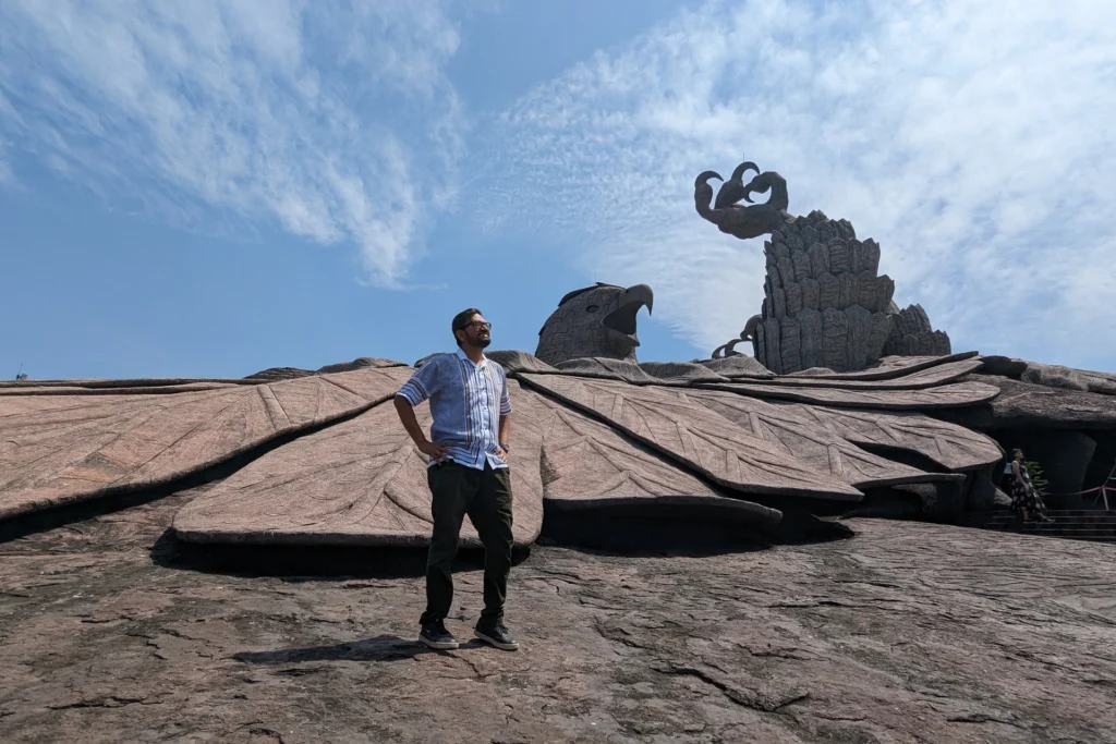 A man with backdrop of Jatayu Sculpture in Kerala