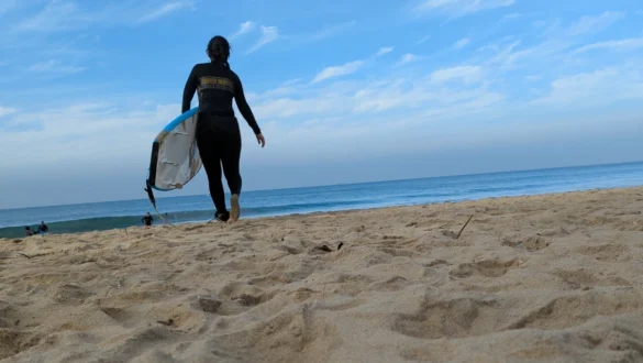 A girl with surfboard on Varkala beach