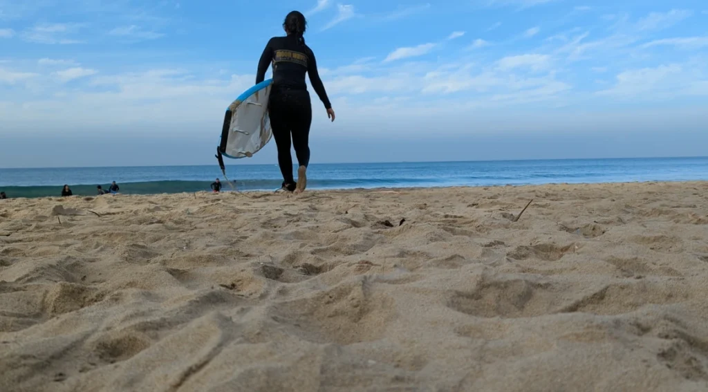 A girl with surf board on a Varkala beach